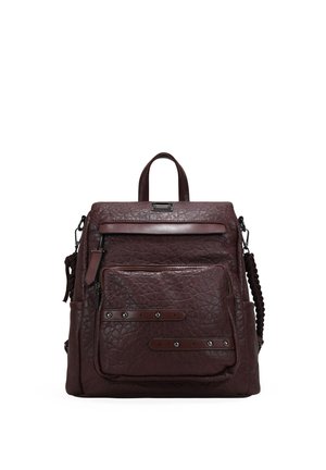 Mochila de cuero marrón con acabado texturizado, equipada con un asa superior, correas ajustables y varios bolsillos exteriores con cremallera.