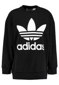 Černá mikina vyrobená z materiálu s hladkým povrchem. Obsahuje velké bílé logo Adidas a tři horizontální pruhy na designu.