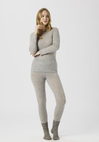 Grau langärmeliges Oberteil und Leggings aus leichtem, weichem Stoff, kombiniert mit gemusterten Stricksocken. Minimalistisches Design, figurbetonte Form.