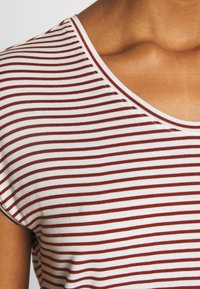 Červeno-bílý pruhovaný tričko s kulatým výstřihem a krátkým rukávem, vyrobené z měkké, elastické látky s hladkým povrchem.