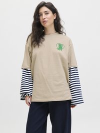 Beige T-Shirt mit einem grünen Motiv auf der Vorderseite, mit gestreiften Ärmel in Marineblau und Weiß. Lockerer Schnitt und weiches Baumwollmaterial.