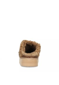 Pantofola marrone pelosa con una parte superiore morbida e testurizzata, apertura arrotondata e suola piatta beige. Design semplice senza decorazioni.