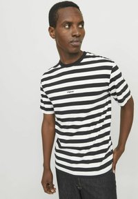 T-shirt i sort-hvide striber med rund hals og korte ærmer, med et lille "Originals"-logo på forsiden.