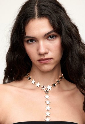 Sternenmotiv-Halskette in verschiedenen Metallen mit abwechselnd silbernen und schwarzen Sternformen, verbunden durch metallische Akzente, mit verstellbarem Kettchen.