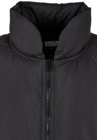 Schwarze gepolsterte Jacke mit hohem Kragen, durchgehendem Reißverschluss und glatter Textur. Das Etikett trägt die Aufschrift "URBAN CLASSICS" und die Größe "M."
