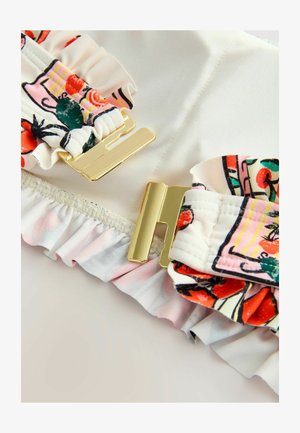 Top da bagno con tessuto arricciato bianco con un motivo floreale colorato, accentuato da fibbie in metallo dorato.