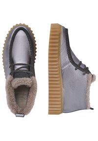 Bottes chevilles argent métalliques avec doublure en fourrure beige, semelle en caoutchouc striée et lacets décoratifs à l'avant et sur le côté.