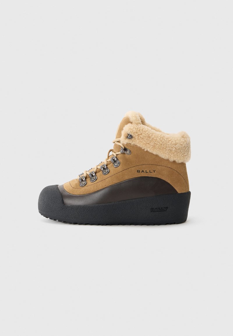 Bota de senderismo de ante marrón con cuello de piel de oveja, suela de goma, ojales de metal y detalle de logo. Diseño de media altura para soporte y comodidad.