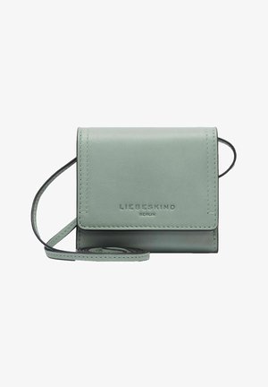 Zielona skórzana portmonetka z klapką, regulowanym paskiem, wytłoczonym logo marki i gładką fakturą. Kompaktowy prostokątny kształt.