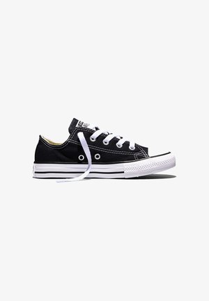 Czarny niski sneaker z płótna z białą gumową podeszwą, ochroną na palce, białymi sznurówkami i widoczną metką marki na języku, pokazany z boku.