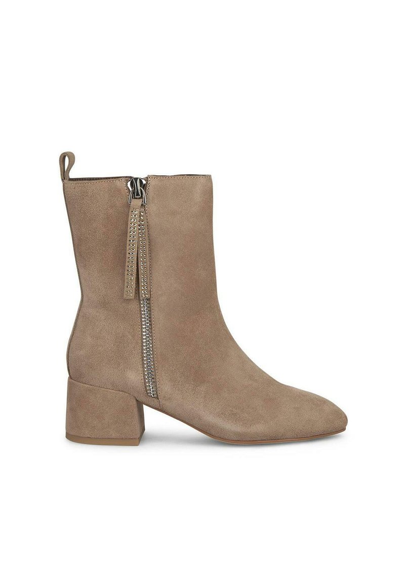 Botines de ante beige con punta afilada y tacón cuadrado, que presentan una cremallera lateral visible y una pestaña en la parte posterior.