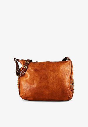 Bruine leren schoudertas met decoratieve metalen bloemenstuds en verstelbare band, op een witte achtergrond.