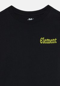 Camiseta negra de cuello redondo con pequeño logotipo amarillo "Element" en el lado izquierdo del pecho.