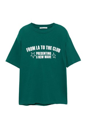 Vihreä puuvillapaita, jossa on lyhyet hihat ja pyöreä kaula-aukko. Paidassa on rohkeaa valkoista tekstiä: "FROM LA TO THE CLUB PRESENTING A NEW WAVE" tähtien kanssa.