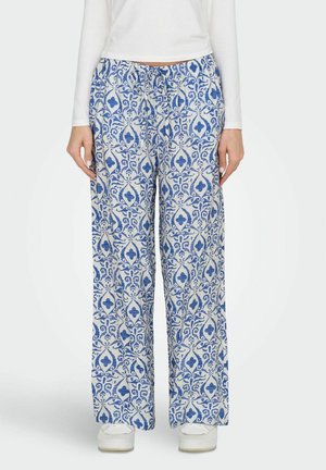 Pantalons à jambes larges en tissu blanc avec un motif damassé bleu complexe. Taille élastique avec un détail de cordon de serrage. Texture lisse.