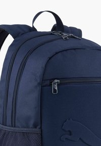 Marineblauwe rugzak van duurzaam materiaal, met meerdere ritssluitingen, een zijvak van gaas en een verhoogd logoaccent. Verstelbare gevoerde schouderbanden.