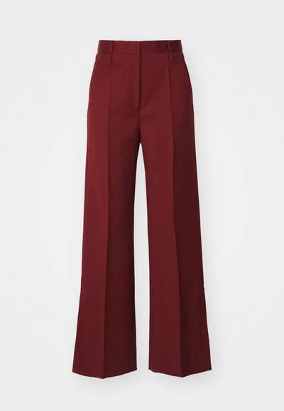 Plati kojinės tamsiai bordo spalvos audinyje, su priekiu raukšlėmis, plokščiu juosmeniu ir nematomomis kišenėmis, turinčios glotnią tekstūrą.