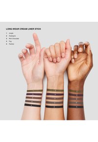 Kolme kohotettua ranneketta, joilla on viisi eyeliner-väriä merkittynä numeroilla 1–5, esittelevät Jungle-, Aubergine-, Rich Chocolate-, Fog- ja Panther-sävyjä eri ihonsävyillä.