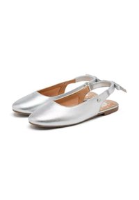 Zapatos planos slingback metálicos plateados con puntera redondeada, parte superior de cuero y una plantilla marrón con patrones de estrellas blancas. Correa ajustable y detalle de lazo.