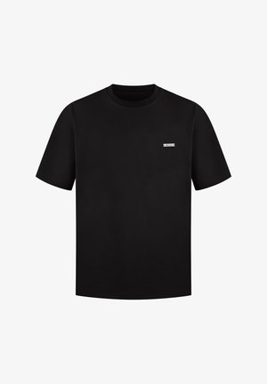 Schwarzes Baumwoll-T-Shirt mit kurzen Ärmeln und Rundhalsausschnitt. Verfügt über ein kleines weißes Etikett im Brustbereich. Glatte Textur.