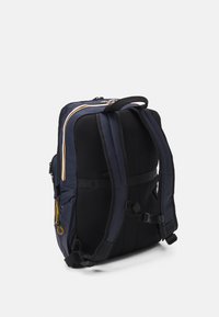 Zaino blu navy con retro in rete, spallacci imbottiti, dettagli gialli e bianchi, e una maniglia superiore. Presenta cerniere e tasche laterali.