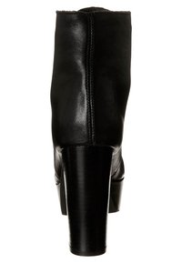 Černá kožená kotníková bota s hladkým povrchem. Vyznačuje se vysokým, robustním podpatkem a elegantním siluetou. Na zadní straně je viditelný šev.