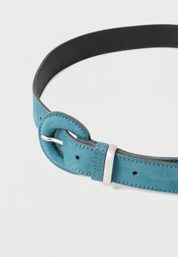 Tummansininen mokkavyö, jossa on sileä pinta, hopeinen solki ja kirjailut yksityiskohdat. Suunnittelussa on useita säätöreikiä.