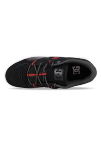 Schwarzer und grauer Sneaker mit Mesh-Obermaterial, runder Schnürung, roten Akzenten und weißer Sohle. Mit Logo auf der Zunge und strukturierten Bereichen für besseren Halt.