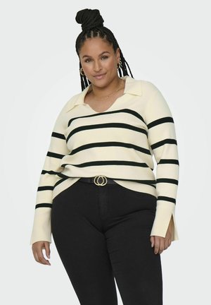 Cream sweater with black horizontal stripes, V-neck, and a collared design. Paired with black jeans and a double-ring belt.