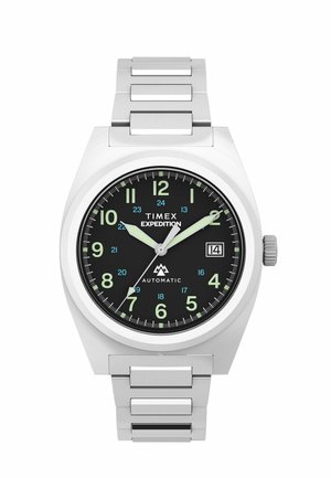 Silver metal Timex Expedition watch with black dial, luminous hour and minute hands, numeric hour markers, and date display at 3 o'clock.