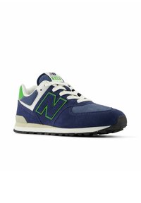 Sneaker New Balance 574 in blu navy e bianco con accenti verdi, lacci bianchi e suola nera, angolato per mostrare i dettagli laterali e frontali.