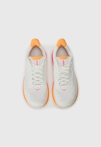 Baskets de sport blanches avec des accents orange et rose, tige en maille légère, lacets, col rembourré et semelles texturées.