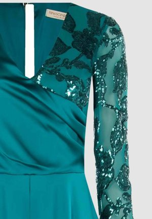 Abito da sera turchese con scollo a V profondo, corpo in raso e maniche lunghe trasparenti con ricamo floreale di paillettes. Lo scollo presenta un'apertura verticale.