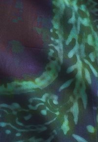 Silke stof med en blanding af mørk lilla og livlige grønne nuancer, med et flydende, abstrakt bladmønster og en glat tekstur.