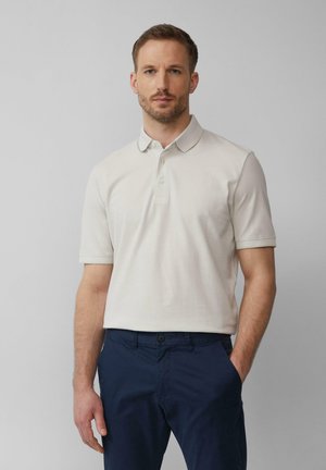 Beige poloshirt met een klassieke kraag en korte mouwen. Gemaakt van een katoenmix, met een subtiele textuur en een drieknoopsluiting.