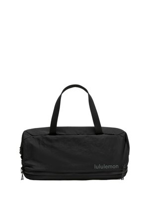 Schwarze rechteckige Lululemon-Tasche mit zwei Griffen und einem Reißverschlussfach unten vor weißem Hintergrund.