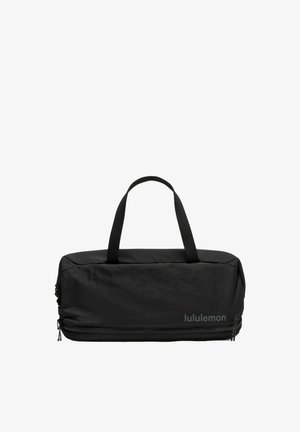 Schwarze rechteckige Lululemon-Tasche mit zwei Griffen und einem Reißverschlussfach unten vor weißem Hintergrund.