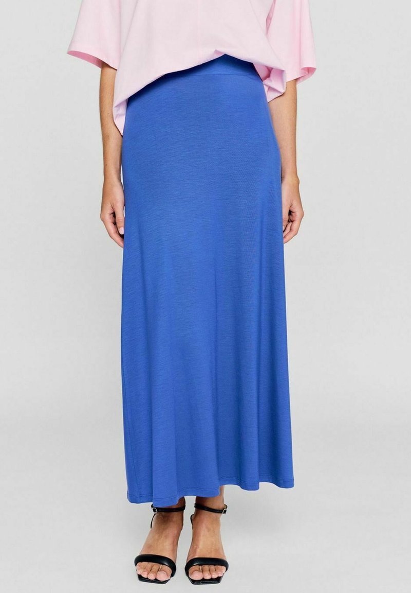 Blaue Maxikjole aus weichem, dehnbaren Stoff. Verfügt über einen eng anliegenden Bund und fließt bis zur Knöchellänge. Kombiniert mit schwarzen Riemchensandalen.