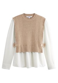 Pull beige en maille à texture côtelée, de coupe courte, avec une chemise blanche en dessous, maintenu par des accents métalliques beiges.