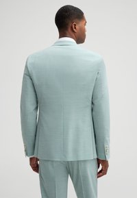 Light blue suit jacket with a smooth texture, structured fit, and four-button cuff accents. Tailored design with a single rear vent.