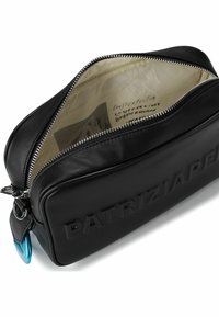 Schwarze Leder-Reisetasche mit Reißverschluss, geprägtem "PATRIZIA"-Logo, glatter Struktur, blauen Metallakzenten und beiger Innenausstattung mit gedrucktem Text.
