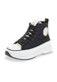 Zapatillas negras de caña alta con acentos blancos, que presentan una puntera texturizada, suela gruesa y un diseño de cordones distintivo. Detalle del logo en el costado.