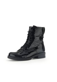 Bottines en cuir verni noir avec un bout arrondi, un laçage sur le devant et des côtés texturés, dotées d'un petit talon carré et d'une semelle contrastante.