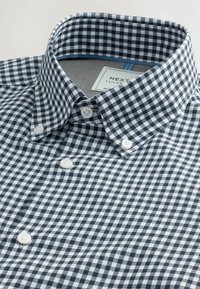 Hemd aus marineblauem und weißem Gingham-Karomuster mit Button-Down-Kragen, weißen Knöpfen und einem Etikett mit der Aufschrift "NEXT Tailored". Aus Baumwollmaterial mit glatter Textur.