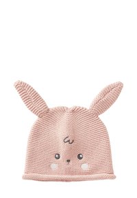 Pletená růžová čepice s ušima králíčka, kulatým obličejem, vyšívanýma očima a tvářičkami s nádechem červeni. Měkká textura a zakončena žebrovaným lemem.