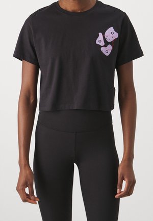 Zwart cropped T-shirt met korte mouwen, voorzien van een kleine cluster van drie onregelmatige paarse vormen met cirkelvormige details op de bovenste linkerborst.