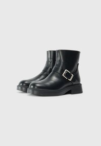 Bottines en cuir noir avec un bout rond et un détail de boucle sur le côté. Semelle en caoutchouc robuste et finition lisse.