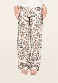 Pantaloni a gamba larga in tessuto bianco con un motivo floreale marrone e nero. Progettati con una vita elastica e tasche laterali.