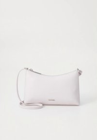 Vaaleanpunainen nahkainen olkalaukku, jossa minimalistinen muotoilu, pyöristetty muoto, vetoketjullinen suljenta ja irrotettava hihna. Sisältää logotunnuksen.