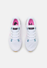 Scarpe da ginnastica bianche con tomaia in mesh traspirante, accenti rosa e dettagli blu. Presentano una suola ammortizzata e un design con lacci.